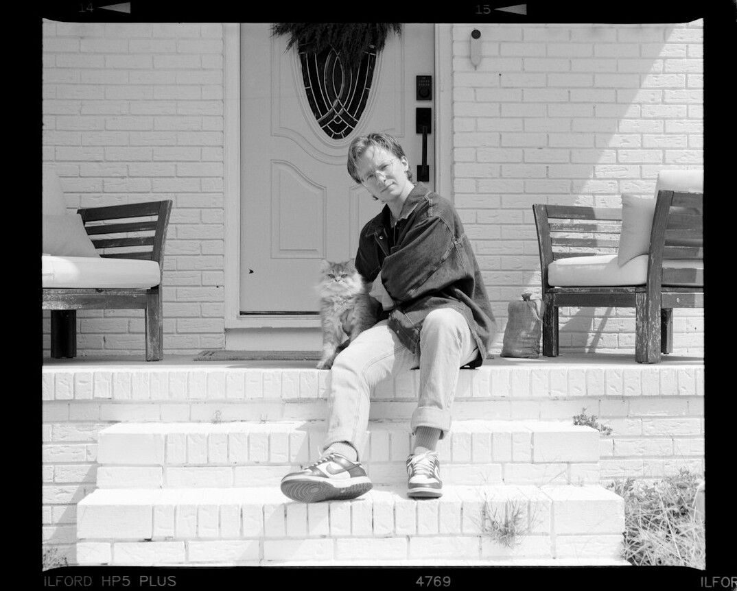 Young man listening to an elderly woman on a front porch
